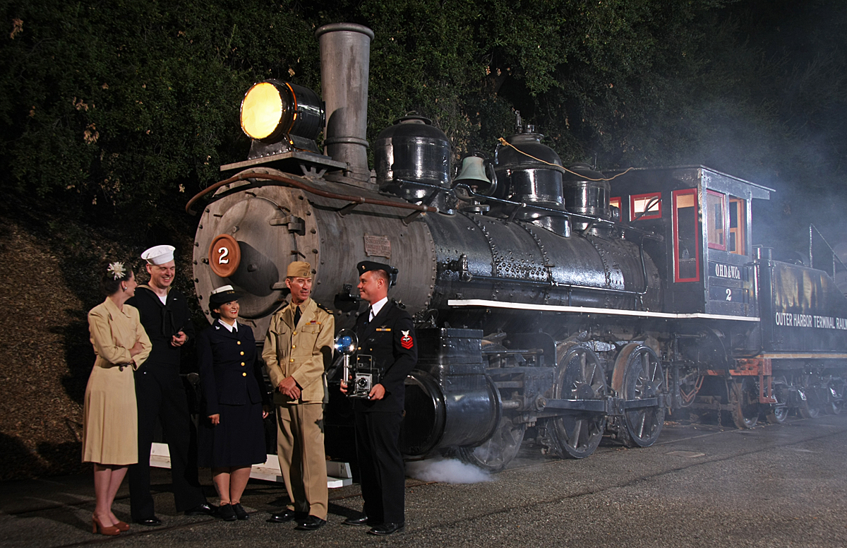 Five People Standing In Front Of A Train